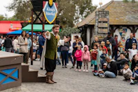 a group of people watching a magician perform in front of a crowd